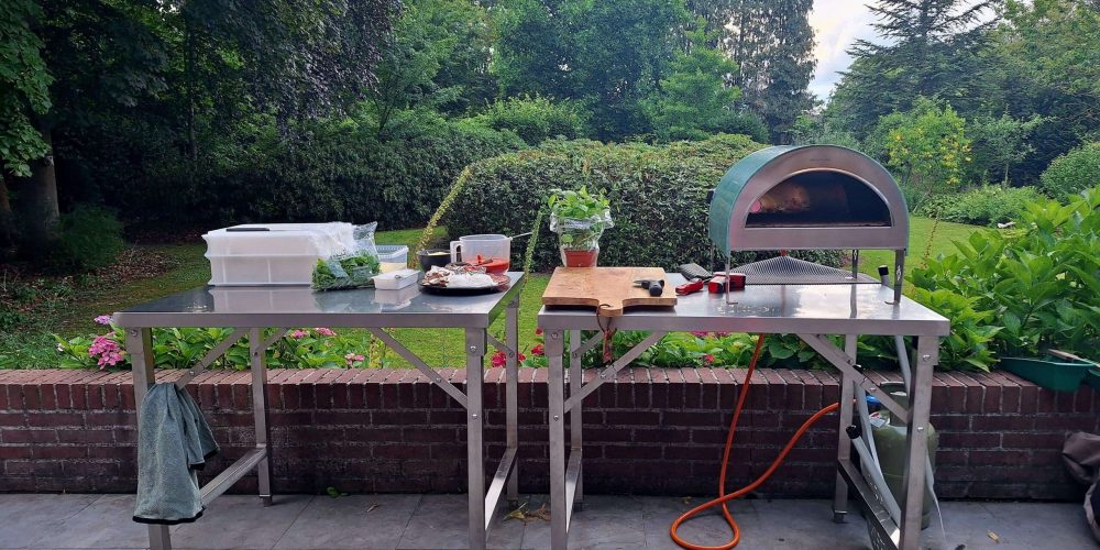 Mobiele pizzaoven op tuinfeest in Gelderland met gasten die zelf pizza bakken.
